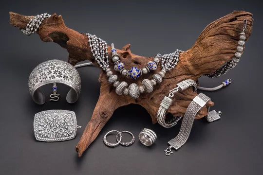Beautiful assortment of 925 silver jewelry, showcasing bracelets, necklaces, and earrings on a wooden surface.